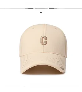Detail view of a beige baseball cap featuring a 3D embroidered C logo and Island text