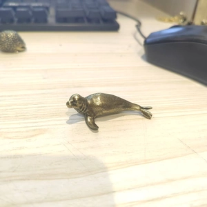 Antique brass seal figurine craft ornament on a minimalist wooden office desktop