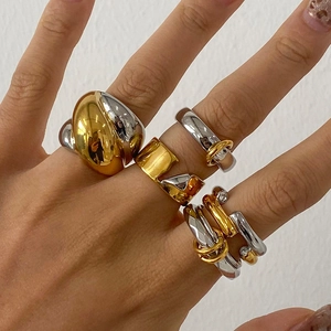 Close-up of mixed gold and silver stainless steel rings with zircon on hands