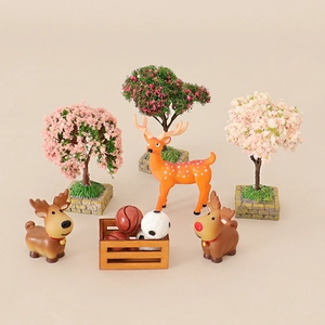 Miniature dollhouse set with colorful Christmas trees, deer figures, and sports ball box