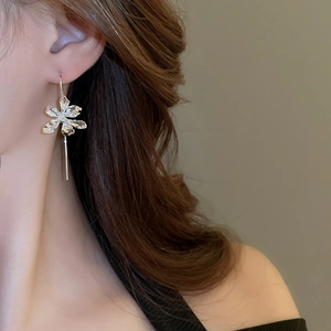 Silver iris flower drop earrings shown on model with elegant long pendant detail