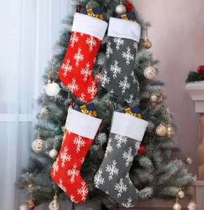 Detail of red and grey knitted Christmas stockings with snowflake patterns on a tree