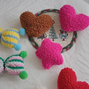 Detailed view of plush lamb wool Christmas ornaments in heart, star and candy shapes