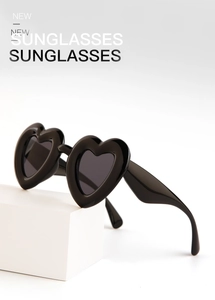 Detail view of stylish heart-shaped black sunglasses on white geometric background