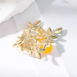 Détail de l'arrière de la broche marguerite avec structure en métal doré et épingle