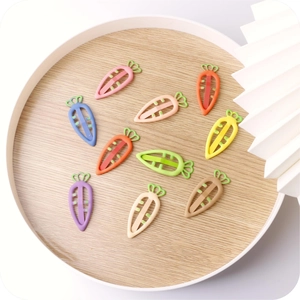 Close-up of colorful carrot-shaped hair clips in various vibrant candy colors on wooden tray