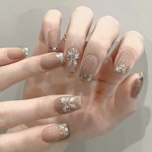 Unghie nude a pressione con sfumature glitter argento e ciondoli a farfalla 3D