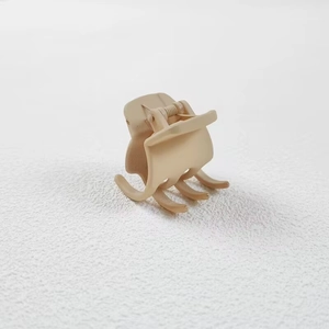 Close-up of 3.5cm matte beige hair claw clip with multi-tooth design on white surface