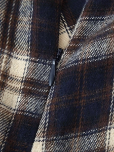 Detailed macro view of plaid wool fabric texture and black invisible zipper closure