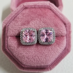Macro detail of square cut pink zircon halo stud earrings in a velvet jewelry box