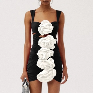 Detail of 3D white floral appliques on a black slim-fit dress with side cut-out