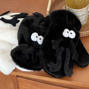 Close-up of cute plush winter gloves with cartoon big eyes and soft furry texture