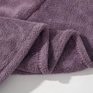 Macro detail of thick purple coral fleece fabric showing soft texture and fine stitching