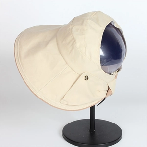 Beige wide brim sun hat with quilted edges and gold metal logo on white background
