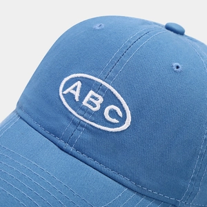 Détail de la broderie ABC blanche sur une casquette de baseball en coton sergé bleu clair