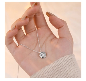 Macro shot of silver rose pendant necklace featuring a sparkling cubic zirconia center stone