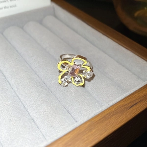Dettaglio dell'anello in argento con smalto floreale giallo e gemma viola centrale