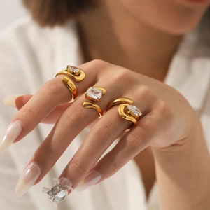Detailed close-up of a three-piece gold open ring set with sparkling zircon stones