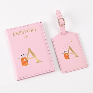 Detail of pink PU leather passport holder and luggage tag set with gold letter A design