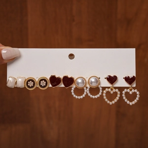 Detail view of 6-pair vintage earring set featuring red enamel hearts and faux pearls