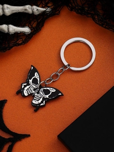 Halloween skull butterfly keychain on orange background with spider web decor