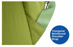 Detail of triangular reinforced stitching on the shoulder strap of a green nylon backpack