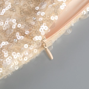 Macro detail of champagne sequins, pearls, and invisible zipper on mesh fabric dress