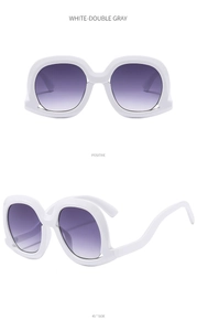 Detail view of white chunky sunglasses with gradient lenses and curved temple design