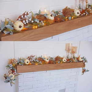 Artificial fall garland with white pumpkins, maple leaves, and warm LED lights on white wood