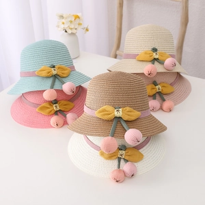 Detailed close-up of woven straw sun hats with cherry accents in five various colors