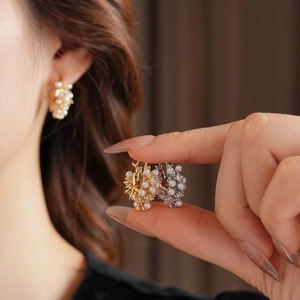 Macro detail of French vintage U-shaped earrings with zircon and pearl clusters