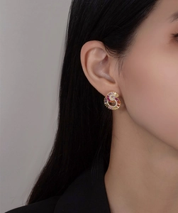 Detail of 925 silver stud earrings with colorful zircons worn by a female model
