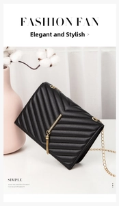 Close-up of black quilted shoulder bag with golden tassel and metal chain strap