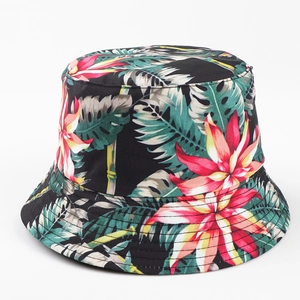 Détail d'un chapeau bob noir avec des motifs floraux tropicaux et des feuilles colorées