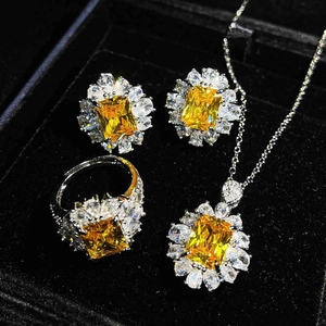 Detailed macro shot of a silver jewelry set with yellow square gemstones in a black box