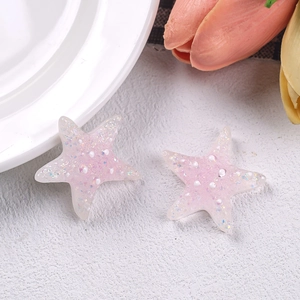 Macro shot of pink glitter starfish resin accessories with mini pearls for DIY crafts