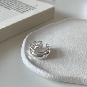 Macro detail of 925 sterling silver ring with hammered texture on a white display plate