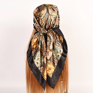 Detail view of a vintage satin scarf with paisley and carriage prints tied on a model