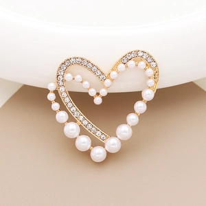 Detailed close-up of a heart-shaped DIY charm with pearls and crystals in gold setting