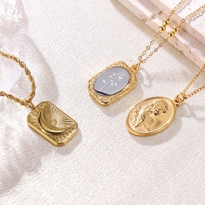 Vintage gold relief necklaces featuring moon sun and rose pendants on white stone