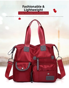 Deep red waterproof nylon travel bag featuring multiple functional front pockets and straps