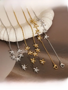 Detailed view of gold and silver starfish jewelry set with zircon on ceramic tray