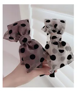 Detail of vintage polka dot bow headbands in brown and grey chiffon with soft lighting