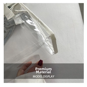 Detail of transparent PVC tote bag with white faux leather trim and reinforced stitching