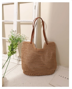 Close-up of khaki hollow-out cotton woven bag featuring slim brown PU leather shoulder straps