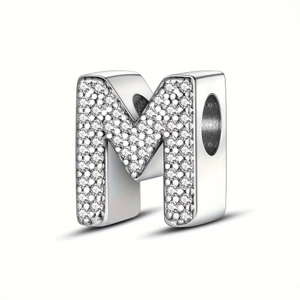 Macro detail of silver letter M bead with micro-pave setting and sparkling zircons