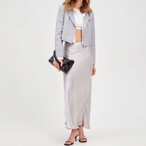 Elegante gonna a sirena in raso argento abbinata a un blazer grigio per un look primaverile