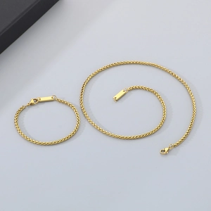 Dettaglio del set collana e bracciale a spiga in acciaio inossidabile dorato con chiusura