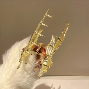 Detailed close-up of golden dragon-shaped metal hair claw clip with scale texture