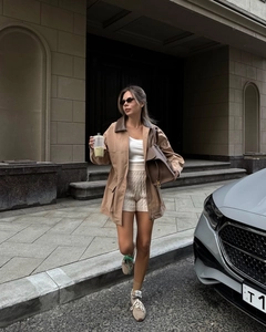 Street style view of khaki utility jacket featuring contrast brown leather collar and pockets